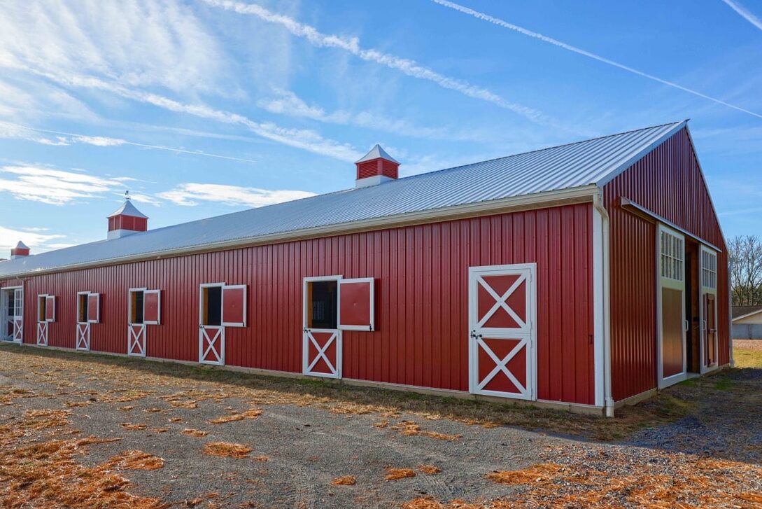 Red metal wagler siding and white metal roofing panels on a barn in Delaware near Wilmington